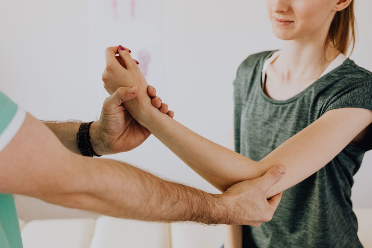 A clinician taking a patient's arm through a shoulder range-of-motion test